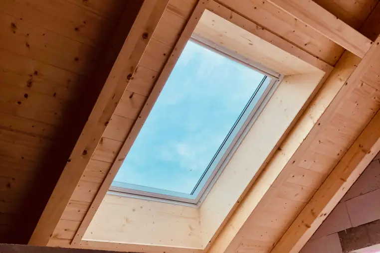 Eingebautes Dachfenster in einer Holz-Dachkonstruktion mit Blick nach außen